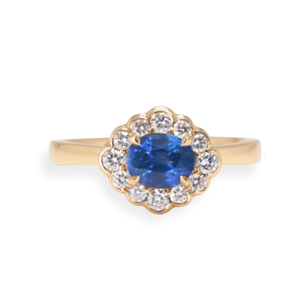 Gold ring with a blue Sri Lankan Sapphire and diamond accents on a white background Zappacosta Jewels