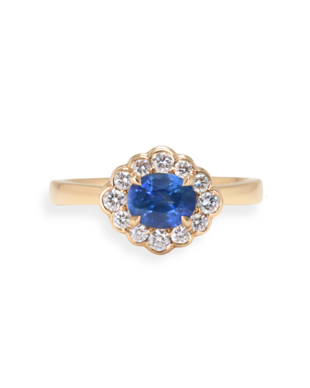 Gold ring with a blue Sri Lankan Sapphire and diamond accents on a white background Zappacosta Jewels
