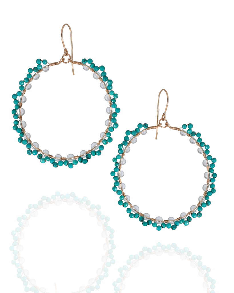 Pair of beaded hoop earrings with turquoise and white beads on a white background