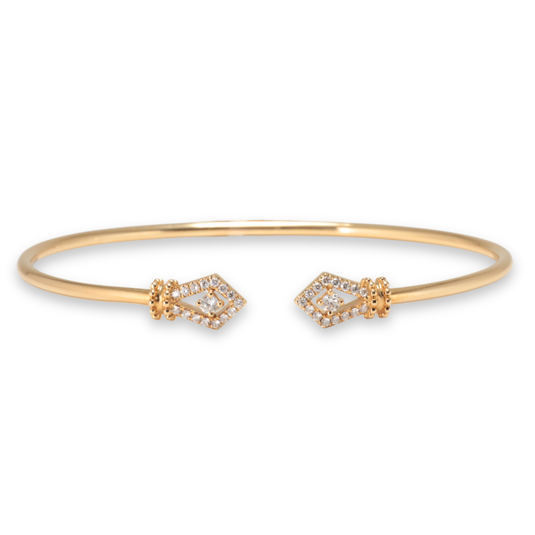 Gold bracelet with decorative diamond ends on a white background