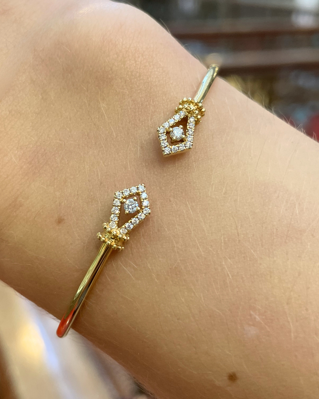 Gold bangle with diamonds on a wrist