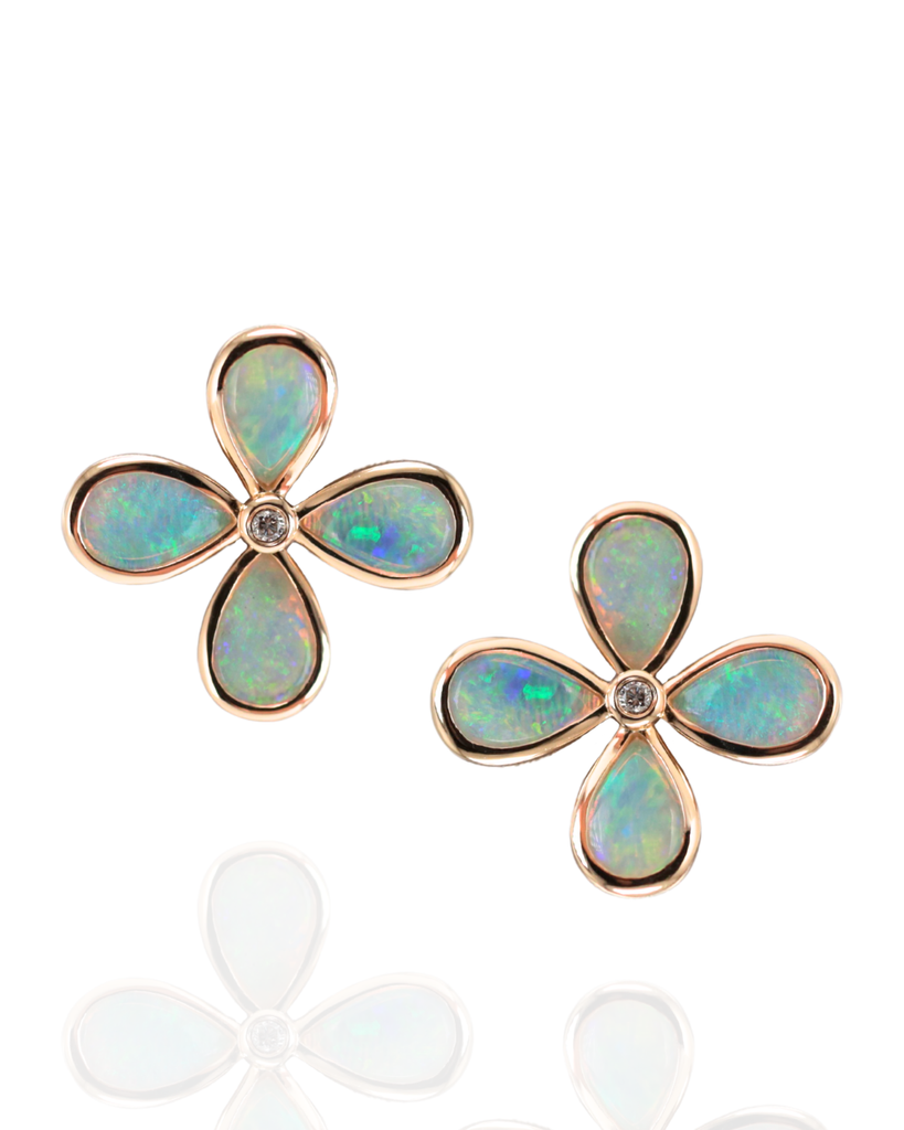 Pair of opal earrings with Yellow gold setting with diamond in centre on a white background