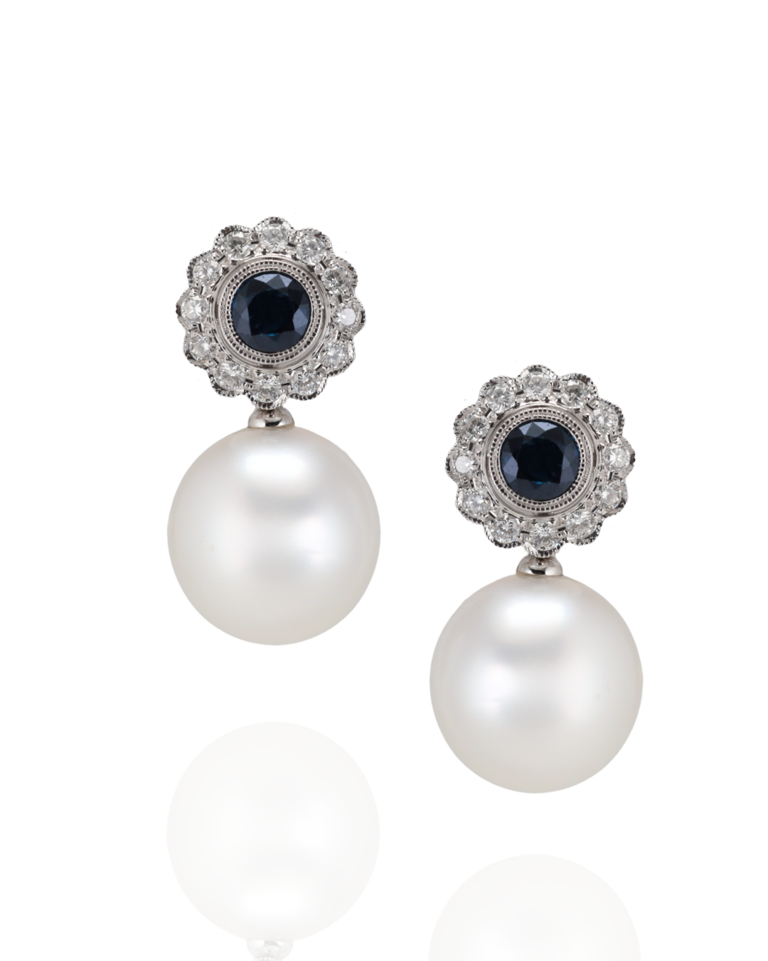 Pair of pearl earrings with gemstone and diamond accents on a white background