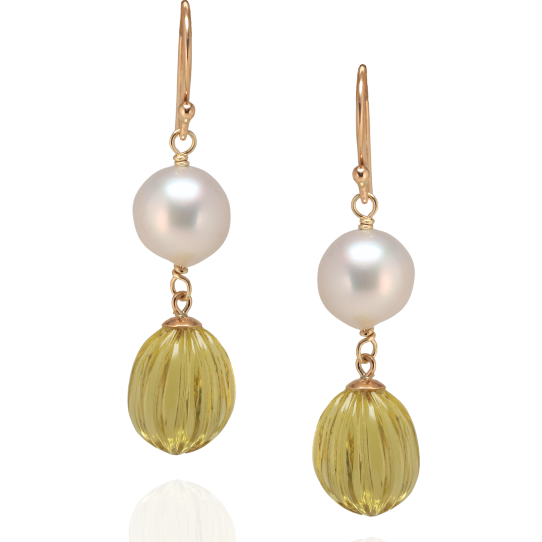Pair of earrings with pearl and lemon quartz ball drops suspended in yellow gold on a white background