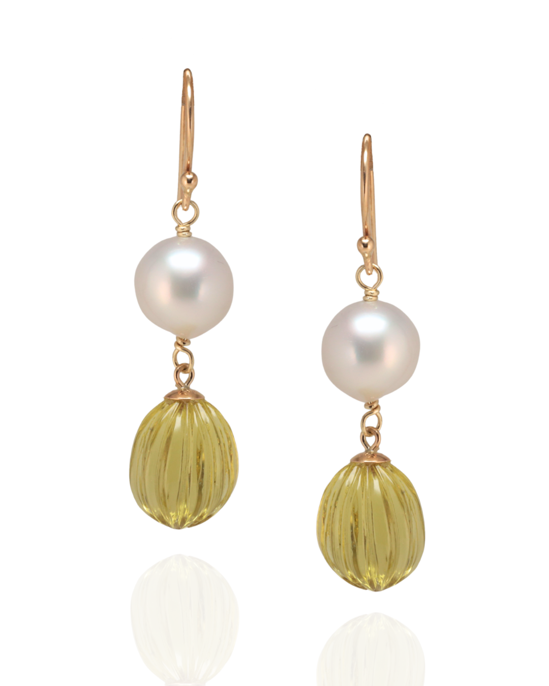 Pair of earrings with pearl and lemon quartz ball drops suspended in yellow gold on a white background