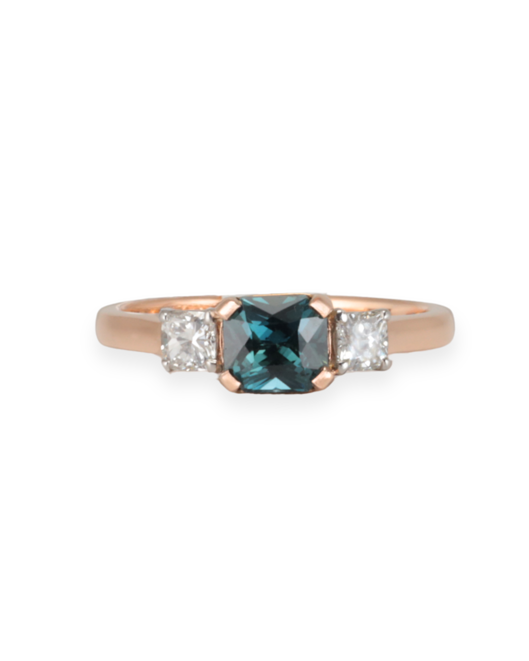Rose gold ring with a teal sapphire gemstone and diamond accents on either side on a white background Zappacosta Jewels 